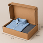 A realistic image of an open 14x10x3 inch corrugated cardboard apparel box containing neatly folded clothing items. The box shows its sturdy construction with clearly visible corrugated texture on the sides. A precisely folded shirt and sweater are visible through the open top, demonstrating professional packaging for medium-sized apparel. Soft lighting highlights the natural brown tones of the kraft cardboard against a neutral background.