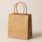 A small, compact twisted handle bag made from premium brown Kraft paper. The bag stands upright with its top slightly open, revealing the spacious interior. It features securely attached twisted paper handles for easy carrying. The natural brown paper has a smooth yet slightly textured finish that highlights its eco-friendly qualities. The bag is photographed against a clean, neutral background with soft lighting that enhances the warm tones of the Kraft paper.