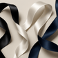 Three ribbons in black, white, and navy blue