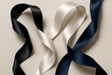 Three ribbons in black, white, and navy blue